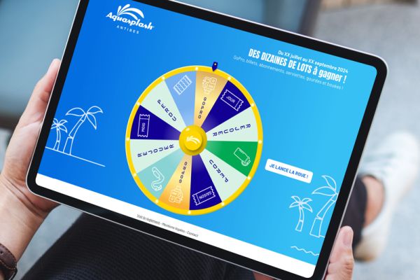 Roue de la chance digitale interactive sur tablette tactile dans un parc d’attractions, animation ludique aux couleurs de l’identité visuelle du parc